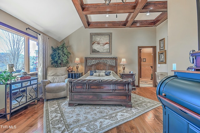 bedroom with coffered ceiling, ensuite bathroom, beamed ceiling, and light wood-type flooring