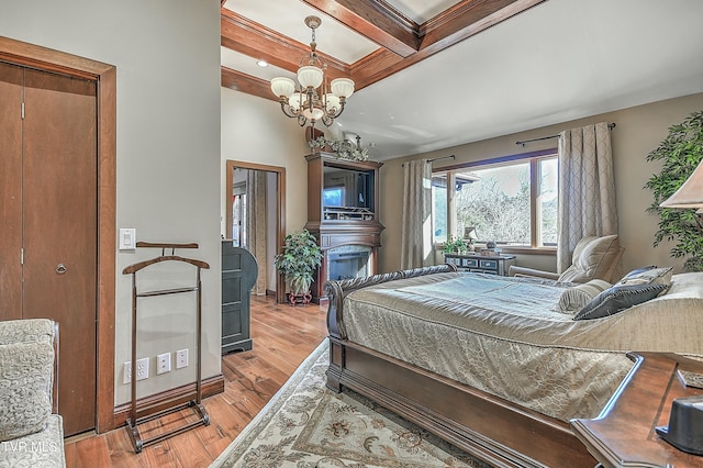 bedroom featuring coffered ceiling, an inviting chandelier, beam ceiling, and light hardwood / wood-style flooring