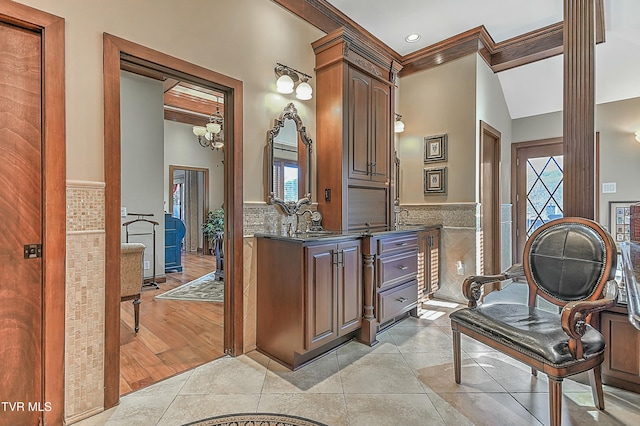 bathroom featuring tile patterned flooring, vanity, tile walls, and crown molding