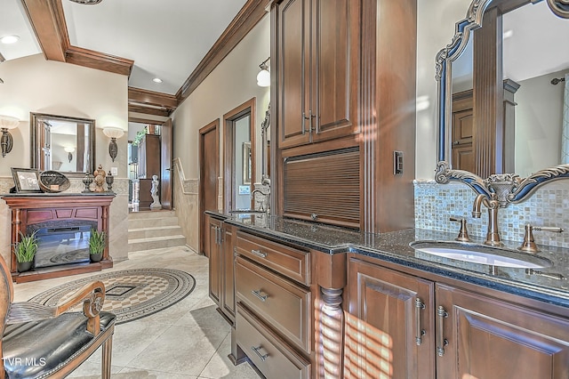 bathroom with tile patterned floors, vanity, ornamental molding, and tasteful backsplash