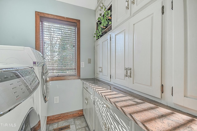 laundry area featuring cabinets, plenty of natural light, and washing machine and clothes dryer