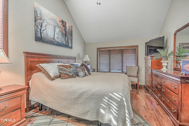 bedroom with lofted ceiling and light hardwood / wood-style floors