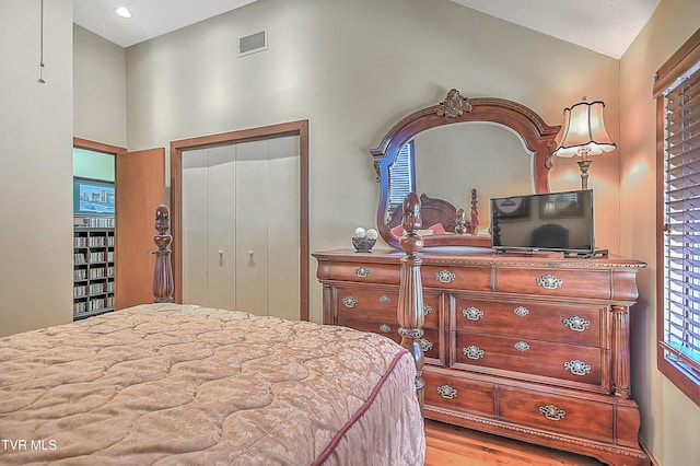 bedroom featuring a closet, lofted ceiling, and light hardwood / wood-style floors