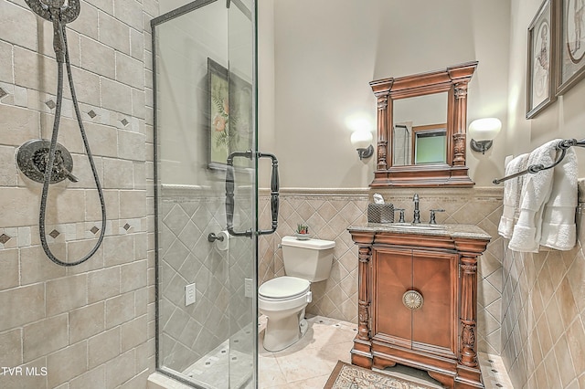 bathroom featuring walk in shower, vanity, tile walls, toilet, and tile patterned floors