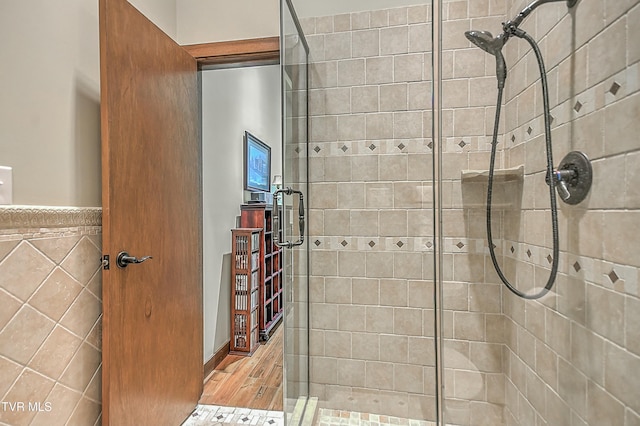 bathroom with walk in shower, tile walls, and wood-type flooring