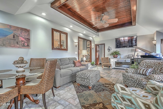 living room with ceiling fan, wood ceiling, and a tray ceiling