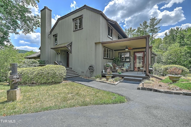 view of front of home featuring ceiling fan, a porch, and a front yard