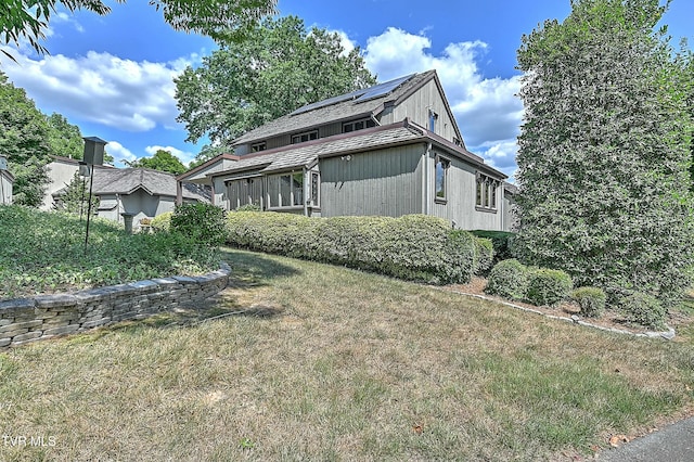 view of home's exterior with a lawn and solar panels