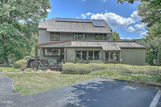 rear view of property with solar panels