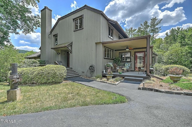 exterior space with a front yard, ceiling fan, and covered porch