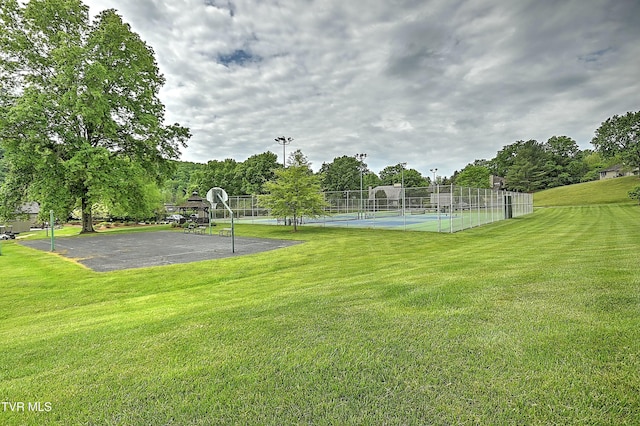 view of sport court featuring tennis court and a yard