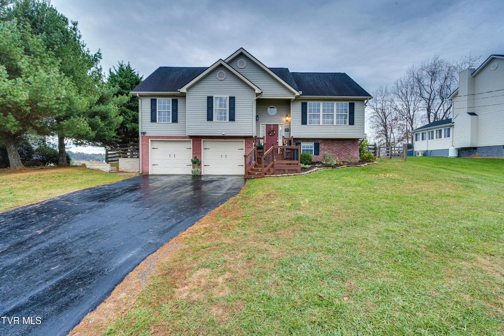 raised ranch featuring a front lawn and a garage