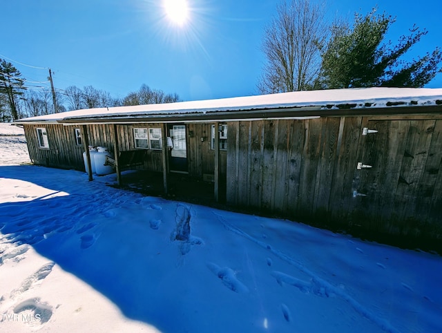 view of snow covered back of property