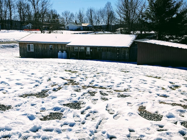 view of snow covered back of property