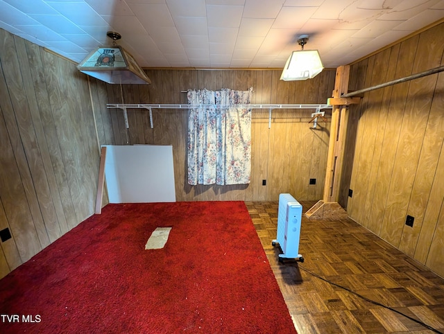 laundry room with dark parquet flooring, radiator heating unit, and wooden walls