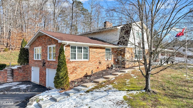 snow covered property with a garage