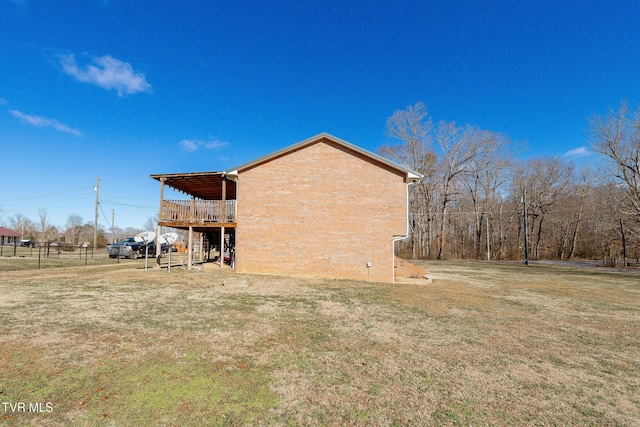 view of side of property featuring a wooden deck and a lawn