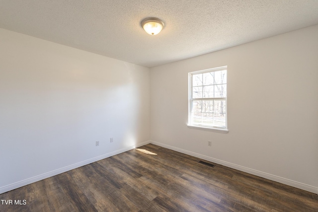 unfurnished room featuring a textured ceiling and dark hardwood / wood-style floors