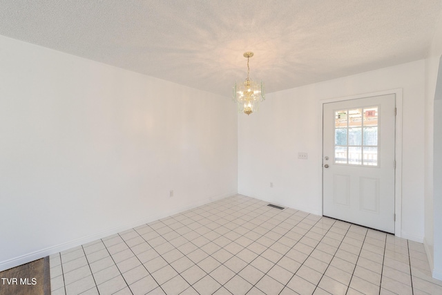 interior space with an inviting chandelier and a textured ceiling