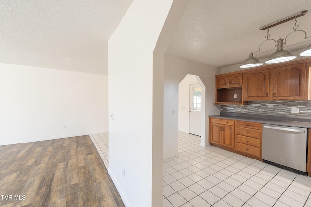 kitchen with a textured ceiling, dishwasher, backsplash, and light hardwood / wood-style flooring