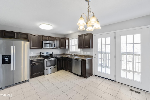 kitchen featuring decorative light fixtures, sink, an inviting chandelier, dark brown cabinetry, and appliances with stainless steel finishes