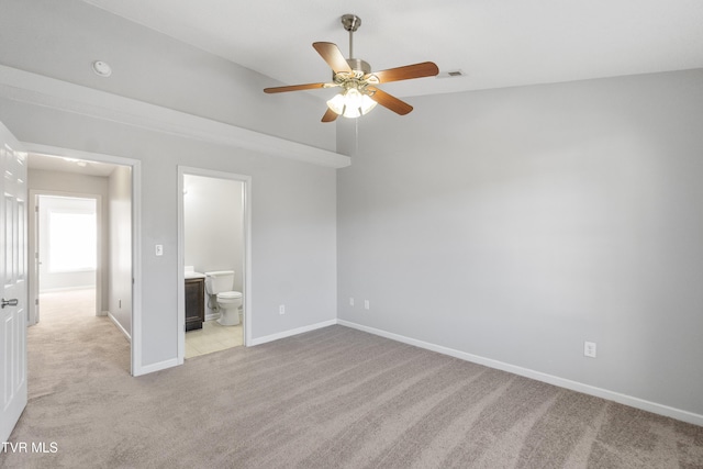 unfurnished bedroom featuring ceiling fan, light colored carpet, and connected bathroom