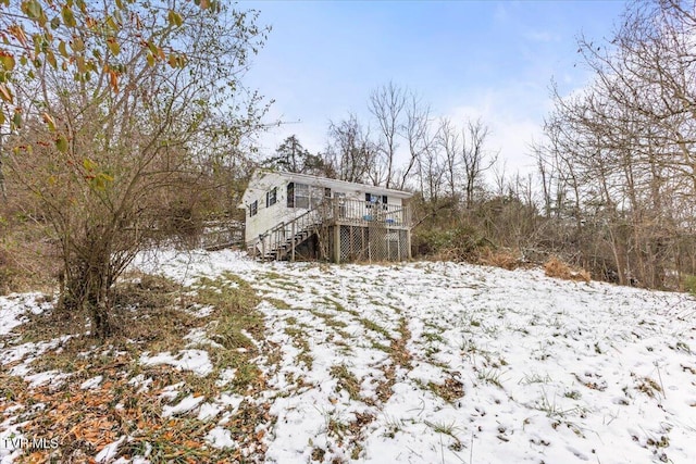 snow covered rear of property with a wooden deck