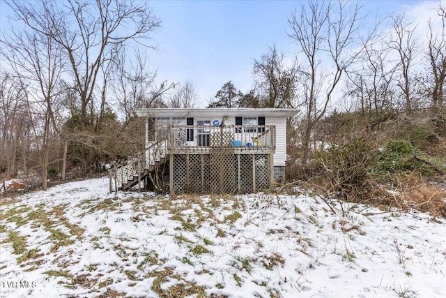 snow covered house featuring a wooden deck