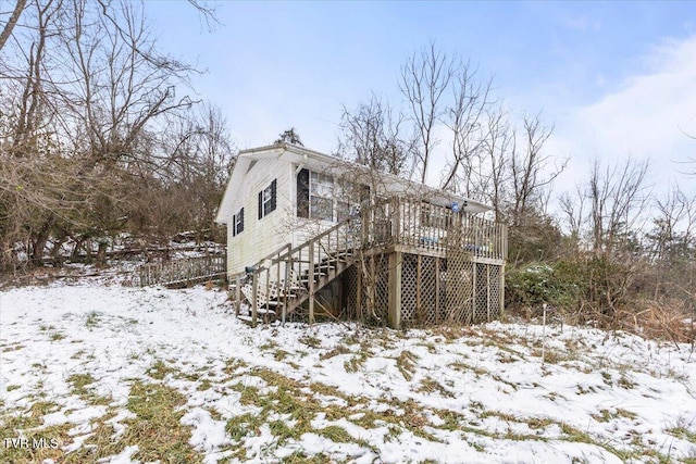 snow covered house with a wooden deck