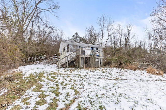 snow covered property with a wooden deck