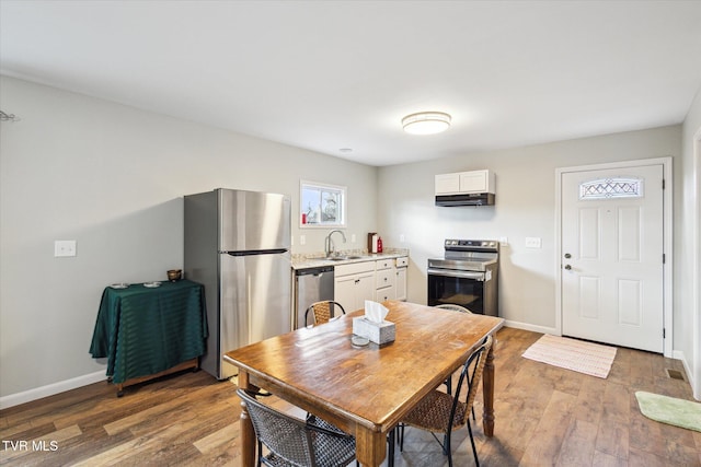 kitchen with sink, white cabinets, hardwood / wood-style flooring, and stainless steel appliances