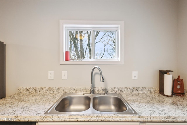 room details featuring sink and light stone countertops