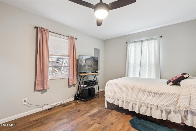 bedroom featuring ceiling fan, multiple windows, and wood-type flooring