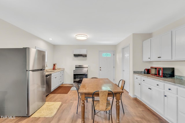 kitchen featuring light stone countertops, white cabinets, and stainless steel appliances