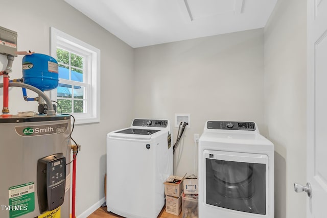 clothes washing area featuring electric water heater and washing machine and clothes dryer