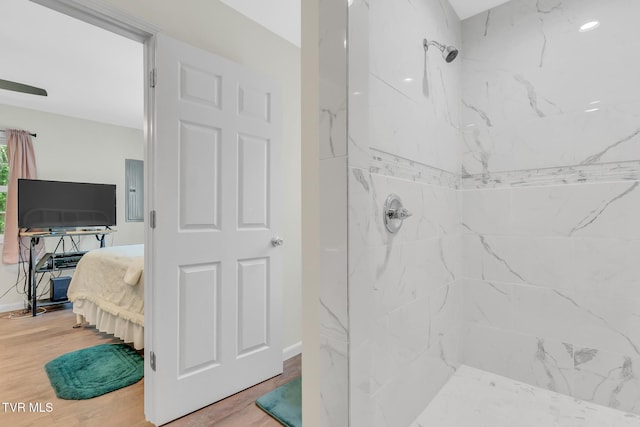 bathroom with hardwood / wood-style floors and tiled shower