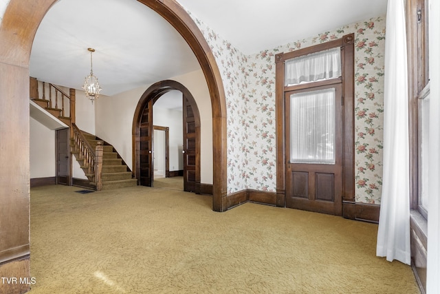 entrance foyer with carpet and a chandelier