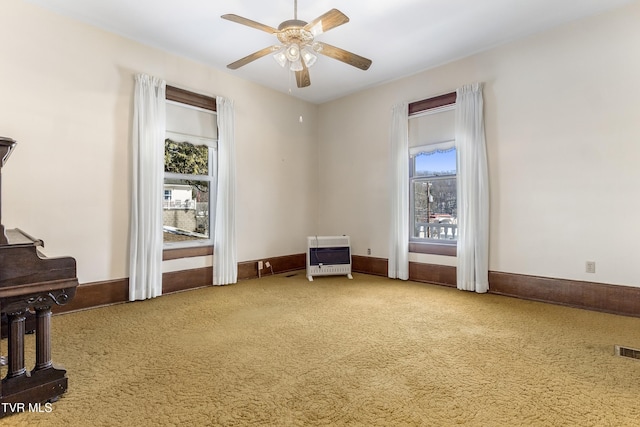 interior space with ceiling fan and heating unit