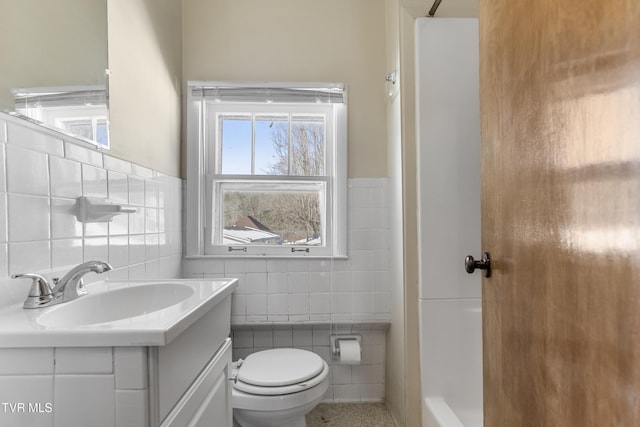 bathroom featuring toilet, tile walls, walk in shower, and vanity