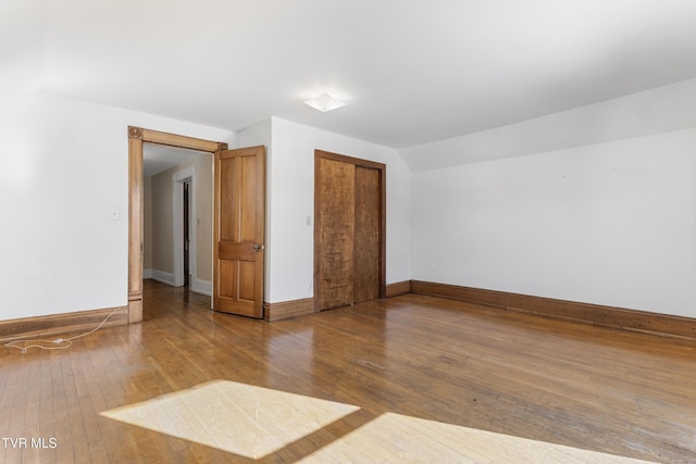 unfurnished room featuring vaulted ceiling and wood-type flooring