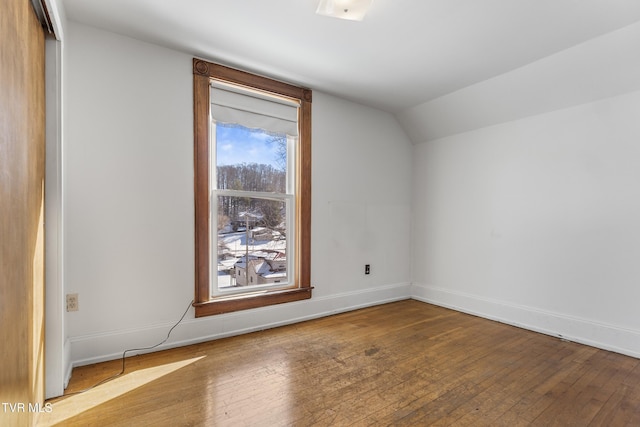 additional living space featuring vaulted ceiling and light hardwood / wood-style flooring