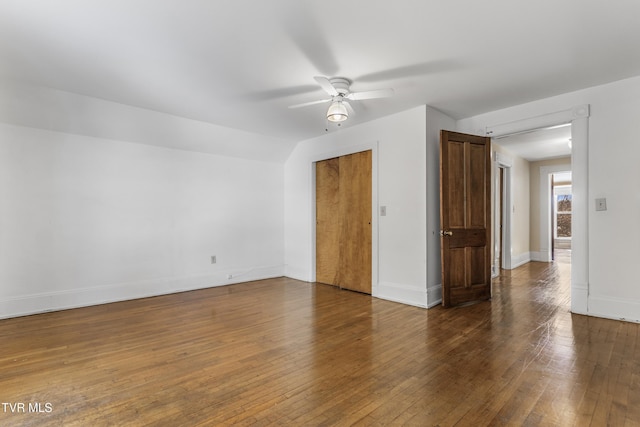 empty room with ceiling fan, dark hardwood / wood-style flooring, and lofted ceiling