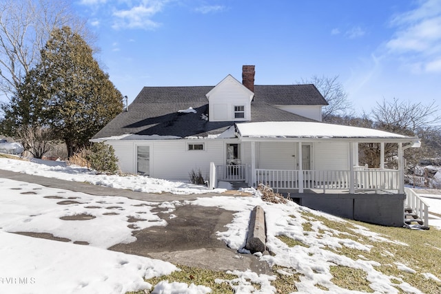 snow covered house featuring a porch