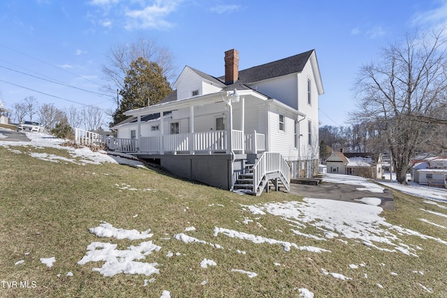 view of side of home with a lawn and a porch