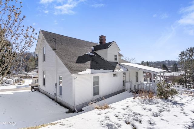 snow covered property with a porch