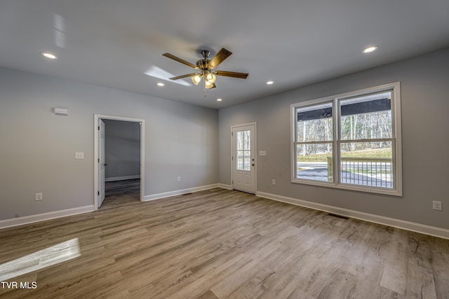 spare room with ceiling fan and light wood-type flooring