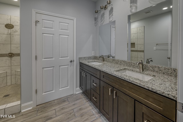 bathroom with vanity and tiled shower