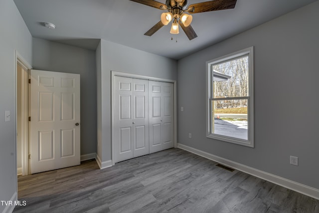 unfurnished bedroom with light hardwood / wood-style floors, a closet, and ceiling fan