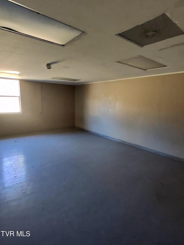 unfurnished room with concrete flooring