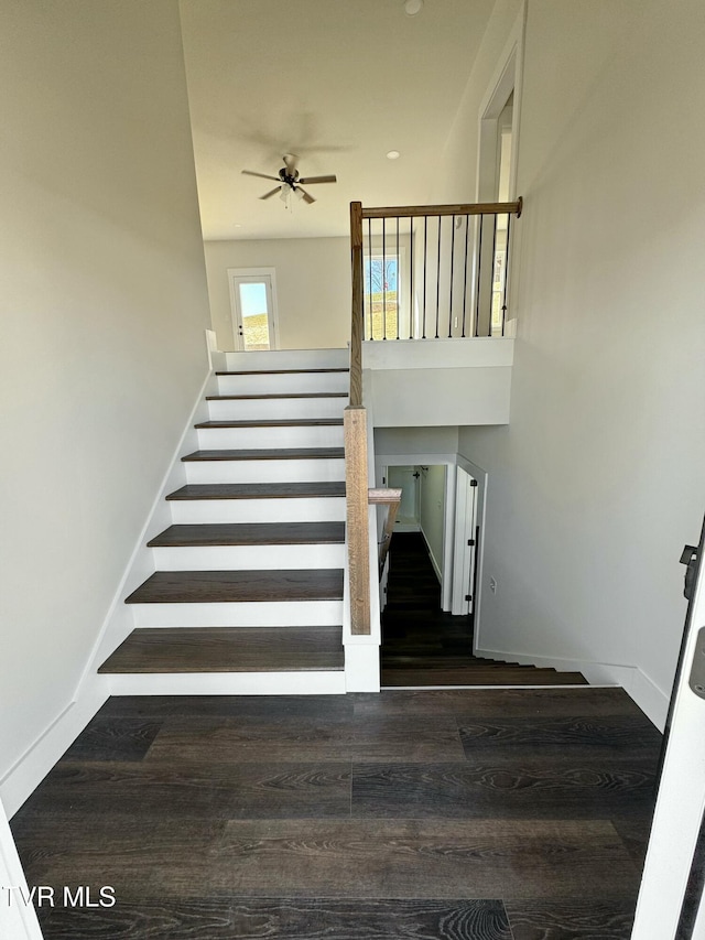 stairs with a ceiling fan, baseboards, and wood finished floors